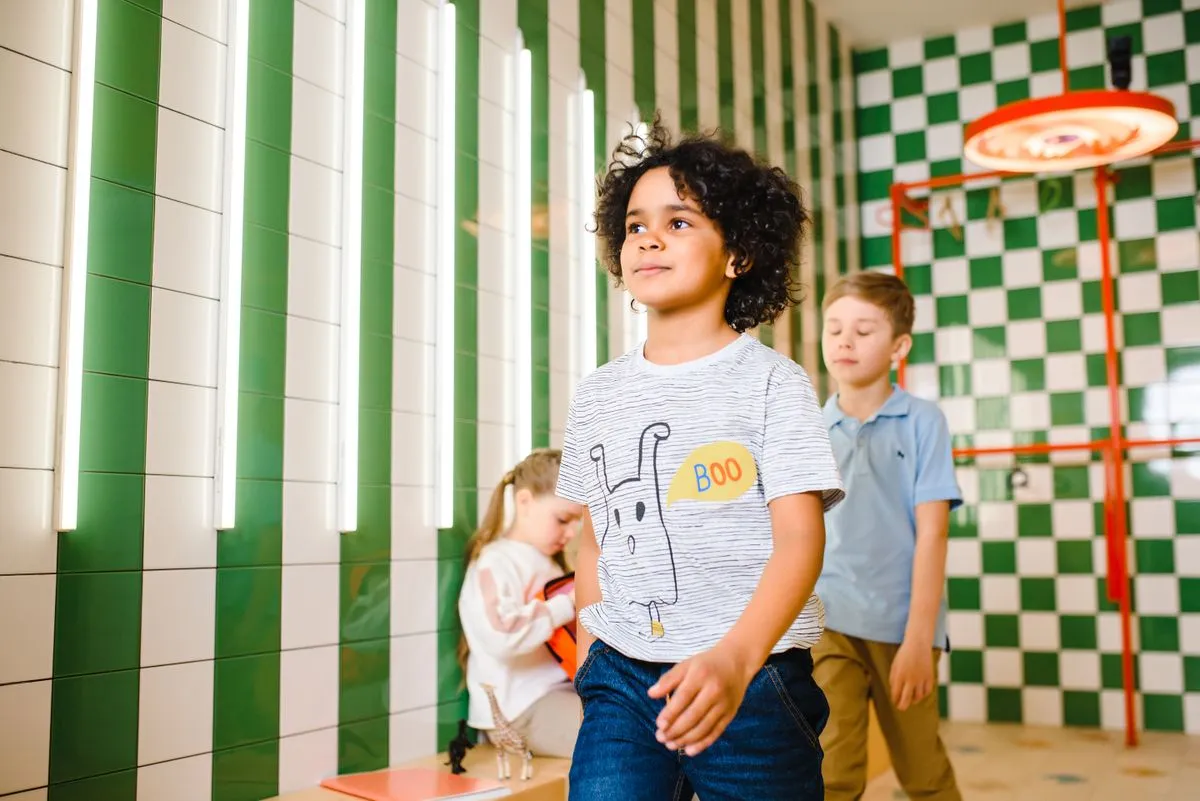 Enfants jouant devant une projection interactive au mur